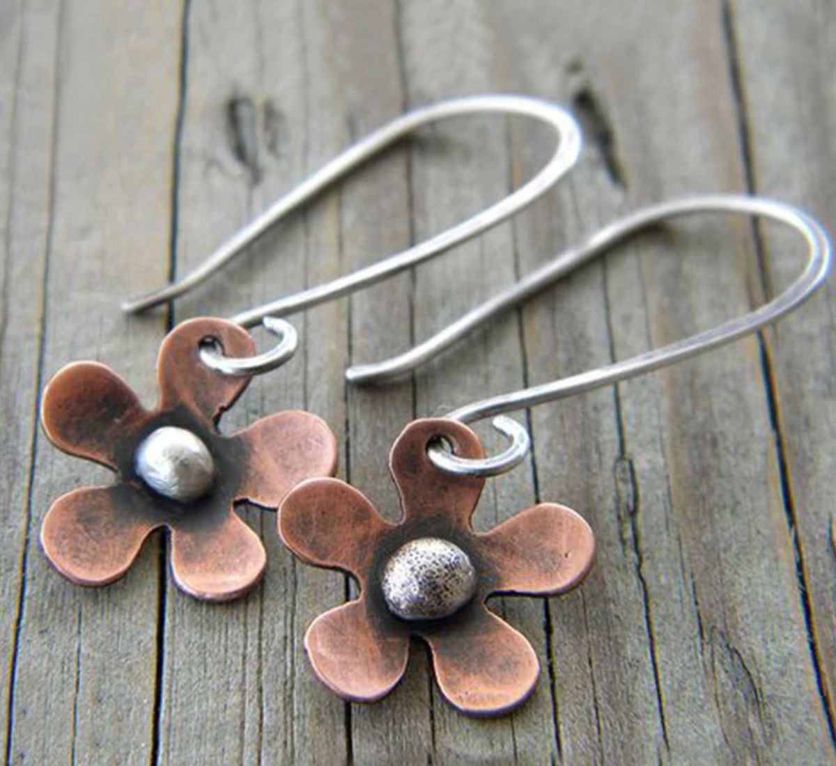 Handmade copper flower earrings with a domed metallic accent