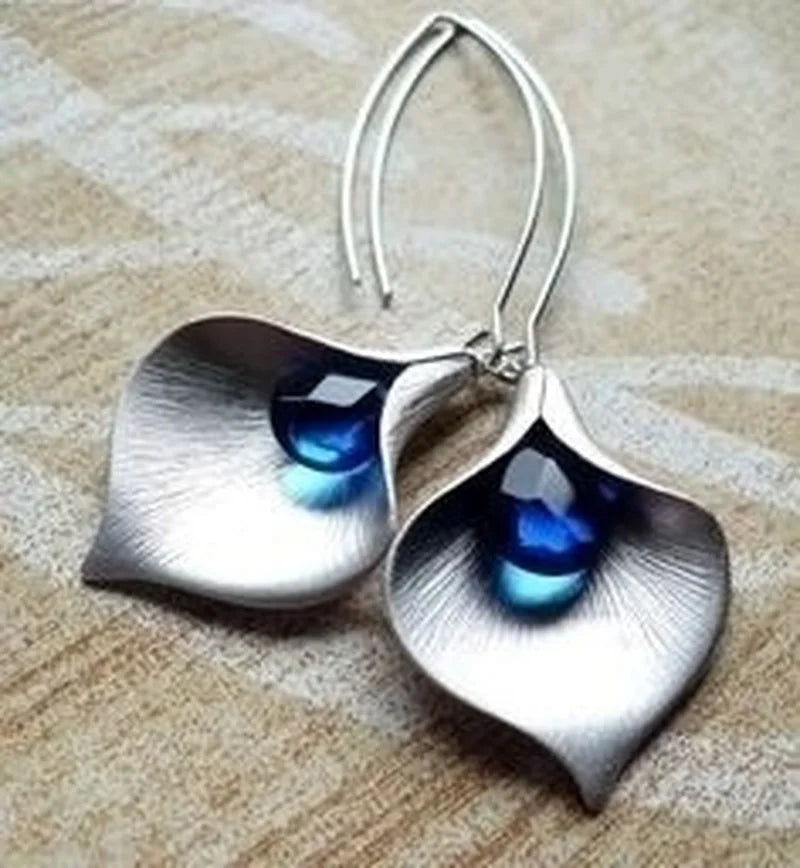 Elegant flower earrings with a sparkling blue teardrop-shaped stone