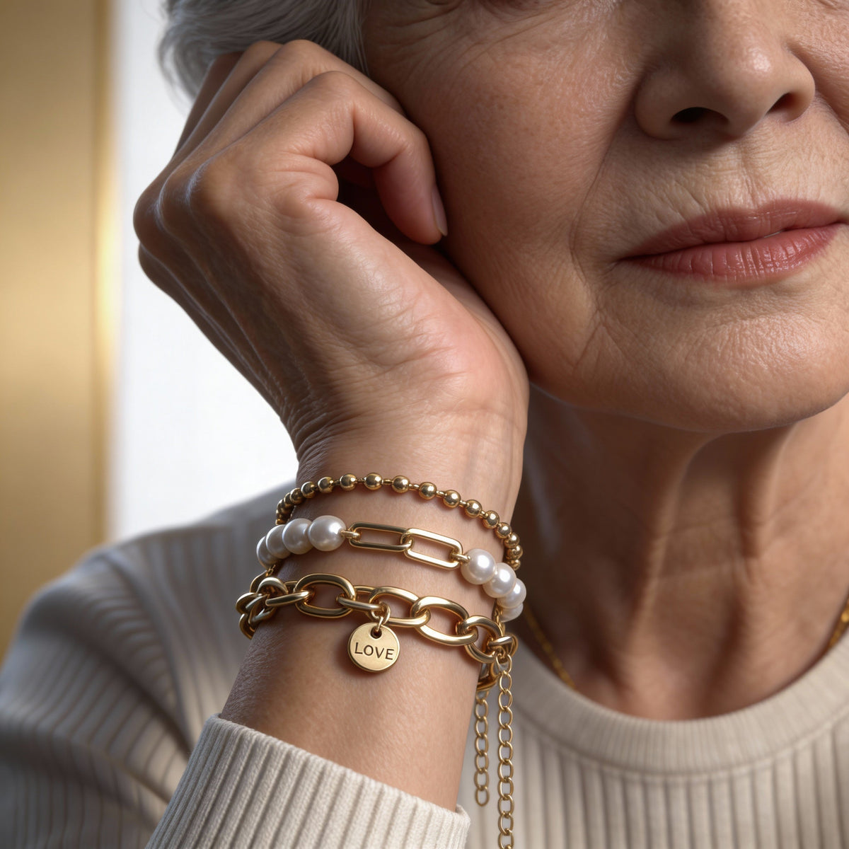 An elegant set of bracelets featuring pearls, chains and a ‘love’ necklace