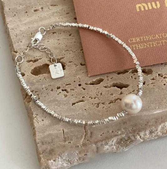 A glamorous bracelet featuring geometric elements, heart-shaped details and pearls