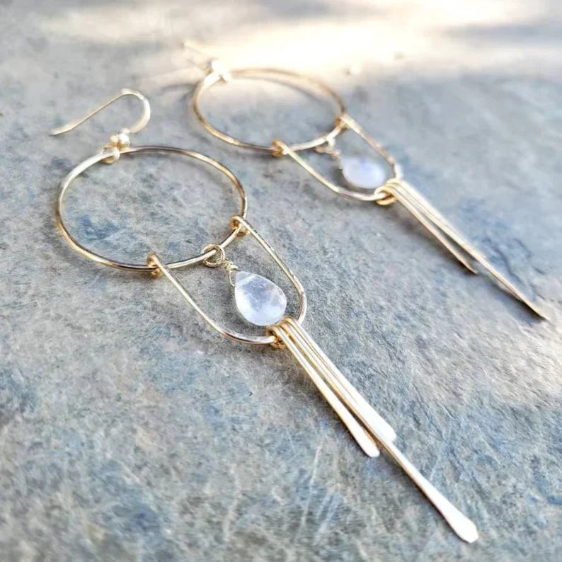 Elegant earrings with a white gemstone and dangling drops