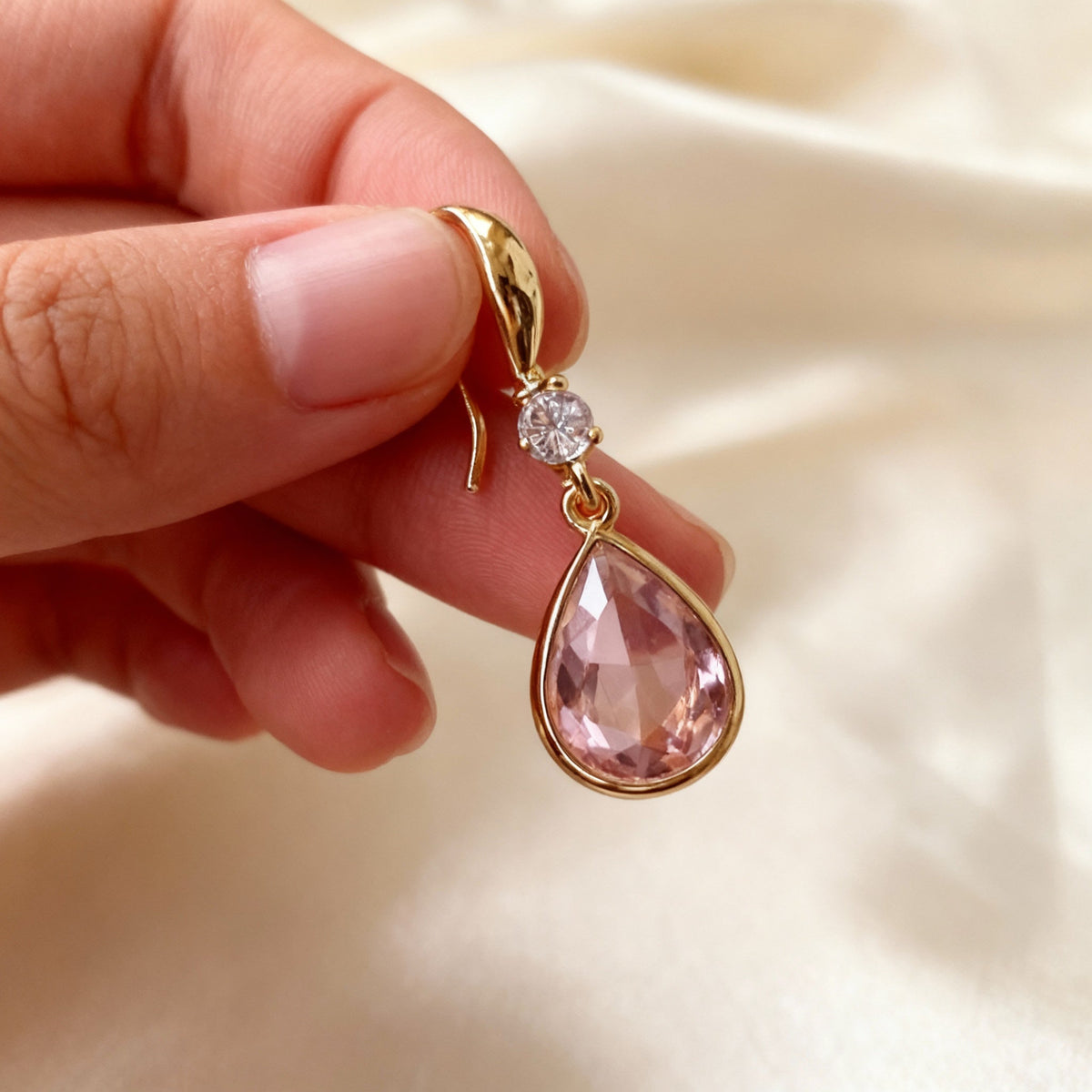 Elegant earrings featuring a pink teardrop-shaped stone and sparkling cubic zirconia