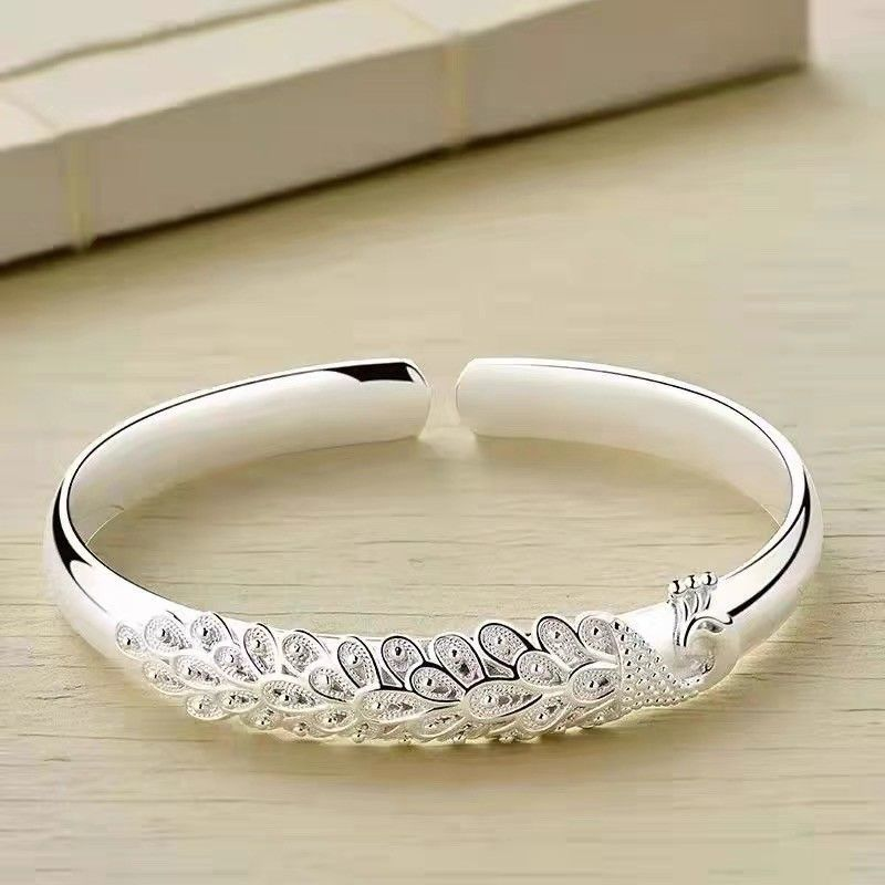 An elegant adjustable bracelet featuring a delicate peacock feather design