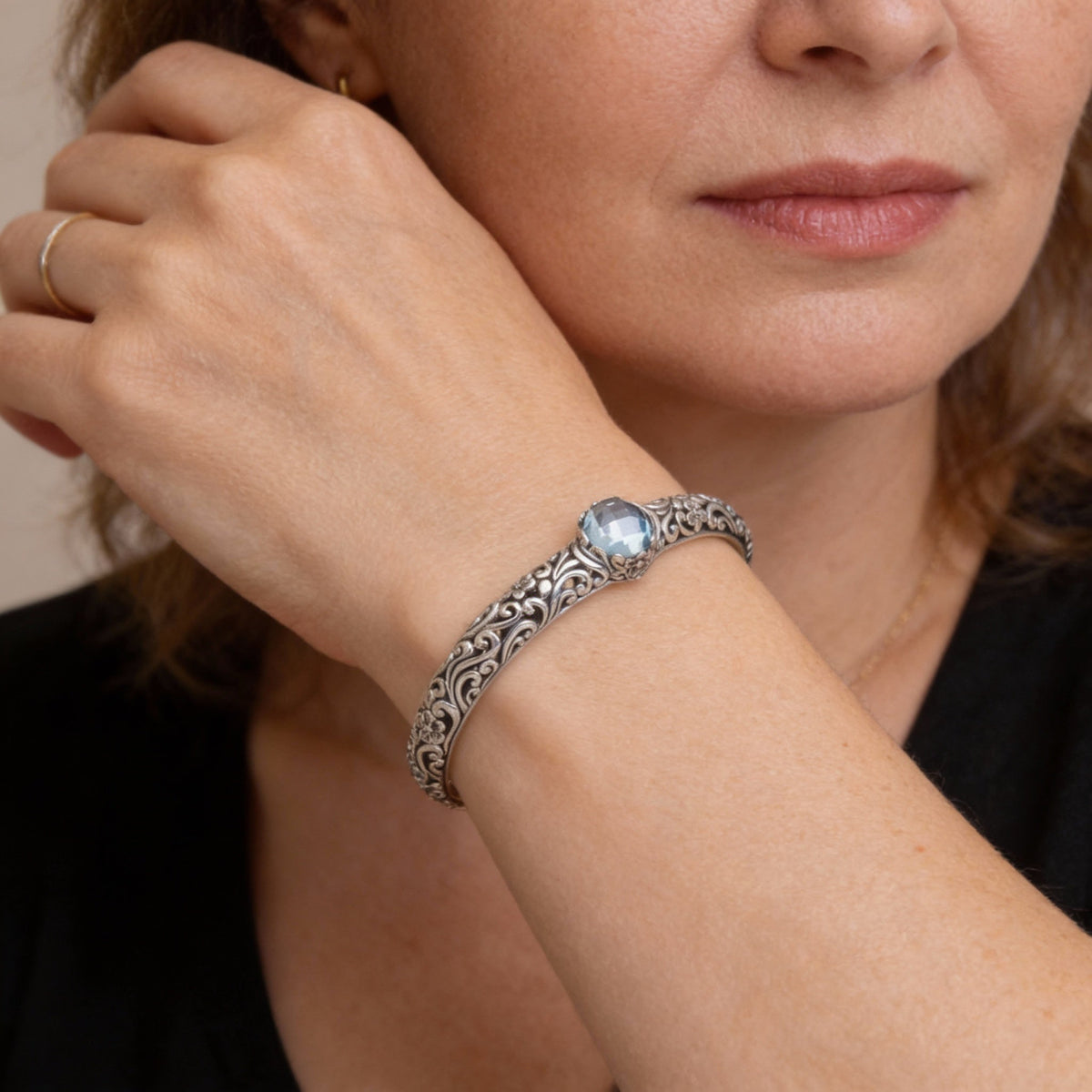 A charming bracelet featuring tendrils, blue topaz and floral motifs