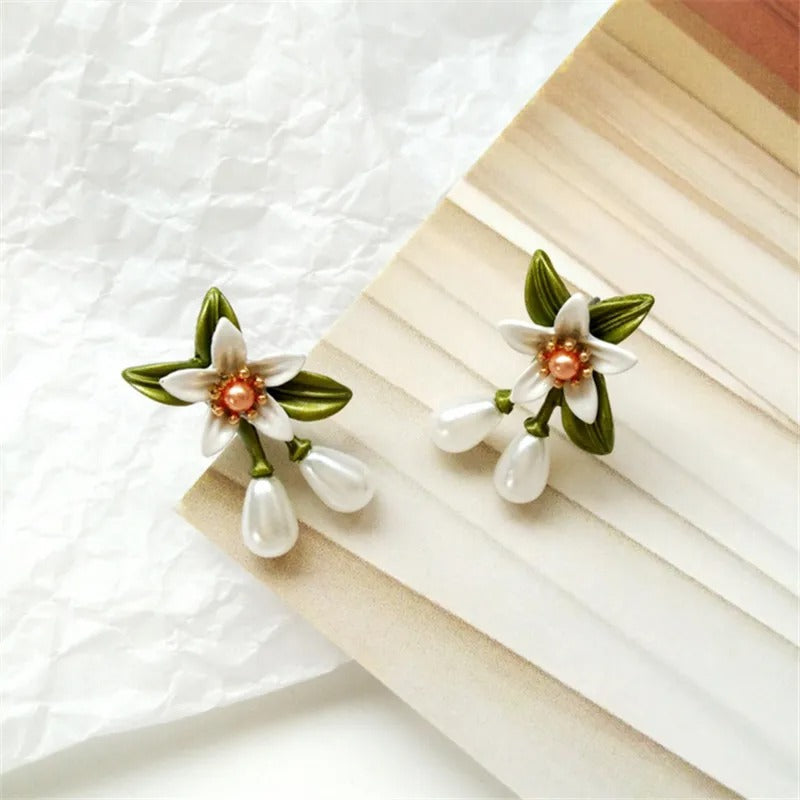 Elegant earrings featuring pearl flowers and green leaves