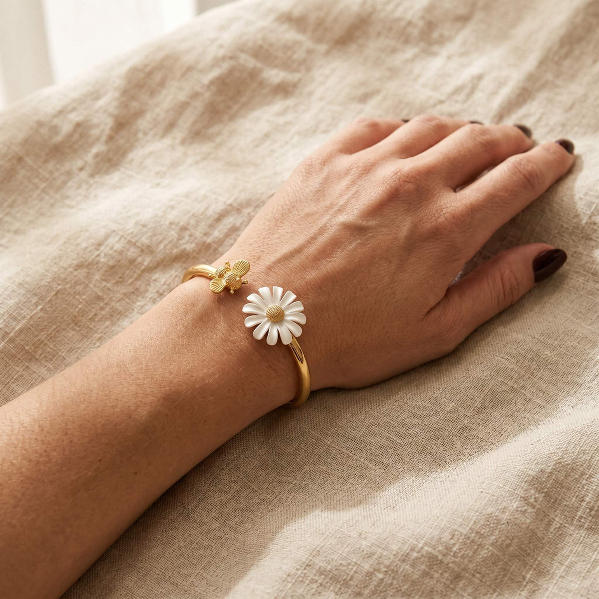 A charming bracelet featuring daisies and bees with floral details