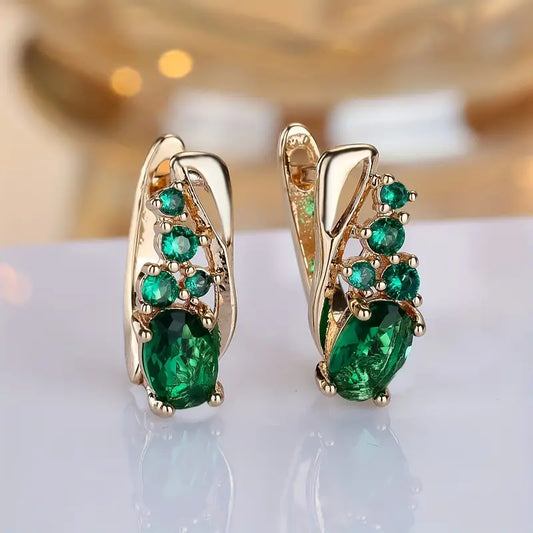 Elegant earrings with emerald-like green stones in a golden hue