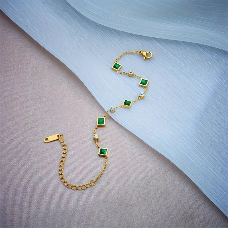 An elegant bracelet featuring square emerald stones and cubic zirconia