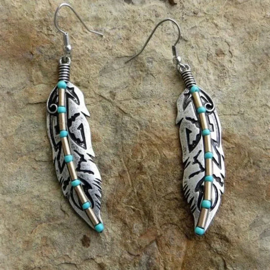 Vintage feather earrings with turquoise beads and an antique-style metal design