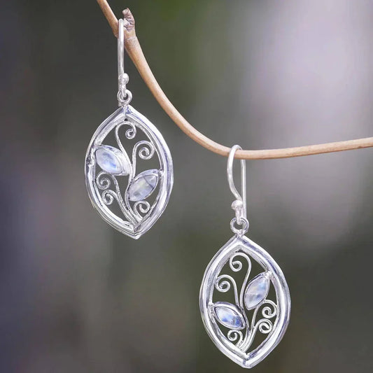 Shiny leaf-shaped earrings with moonstone-shaped details on a branch