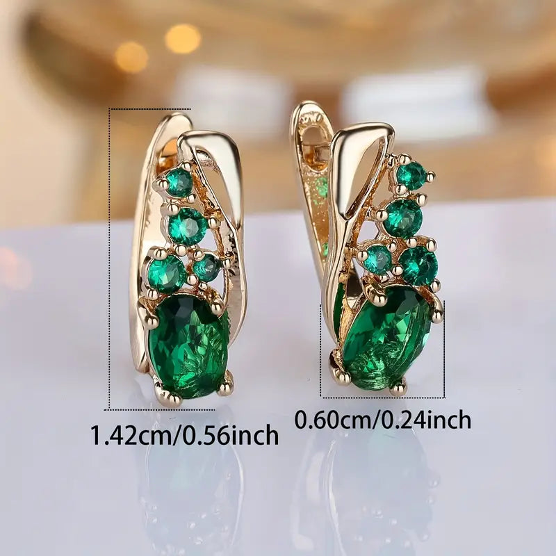 Elegant earrings with emerald-like green stones in a golden hue