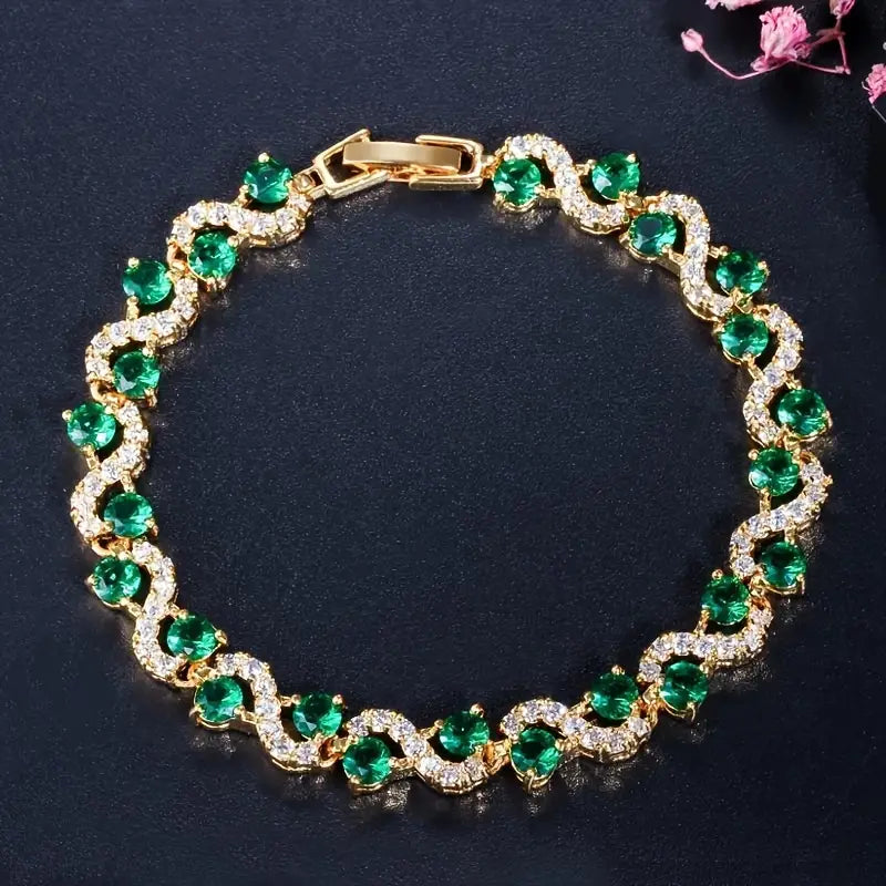 A bracelet featuring brilliant emerald-green cubic zirconia stones in an elegant wave design