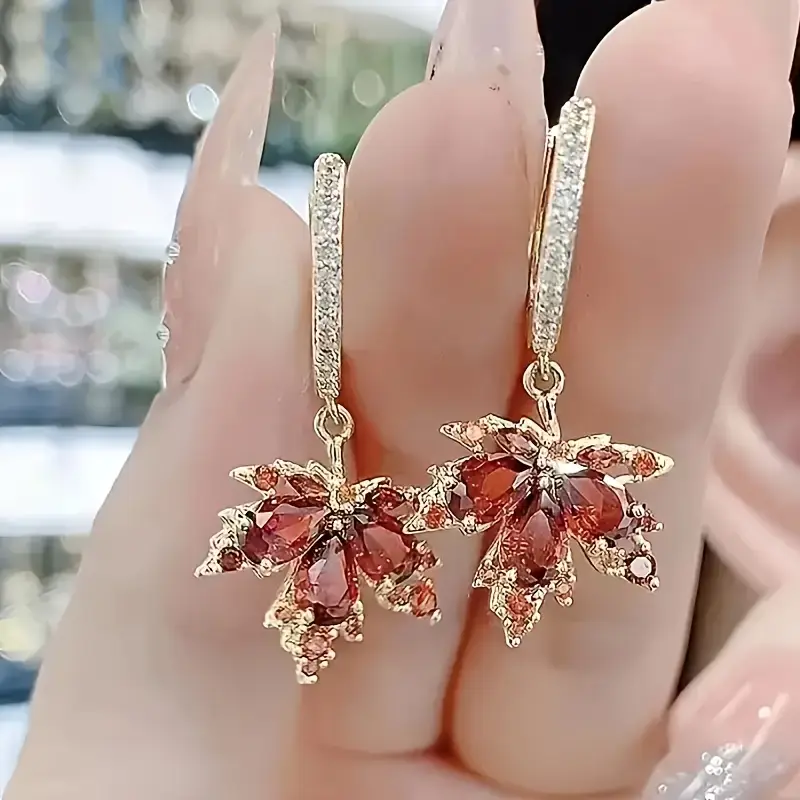 Elegant maple leaf earrings with sparkling red cubic zirconia stones