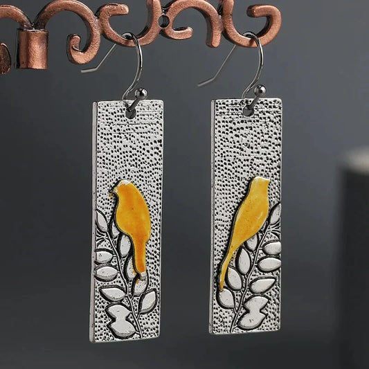Vintage earrings featuring a yellow bird design and a floral drop