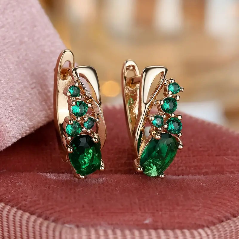 Elegant earrings with emerald-like green stones in a golden hue