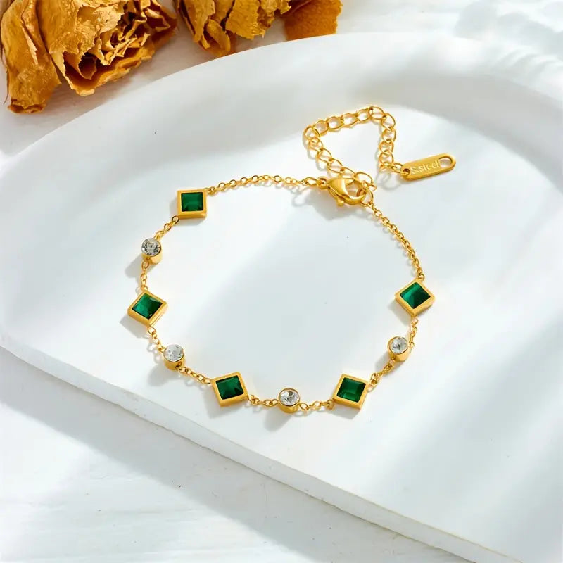 An elegant bracelet featuring square emerald stones and cubic zirconia