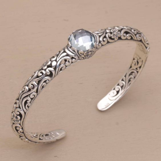 A charming bracelet featuring tendrils, blue topaz and floral motifs