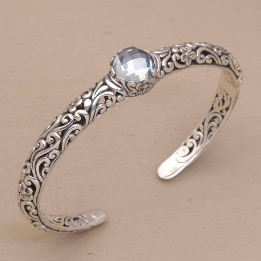 A charming bracelet featuring tendrils, blue topaz and floral motifs