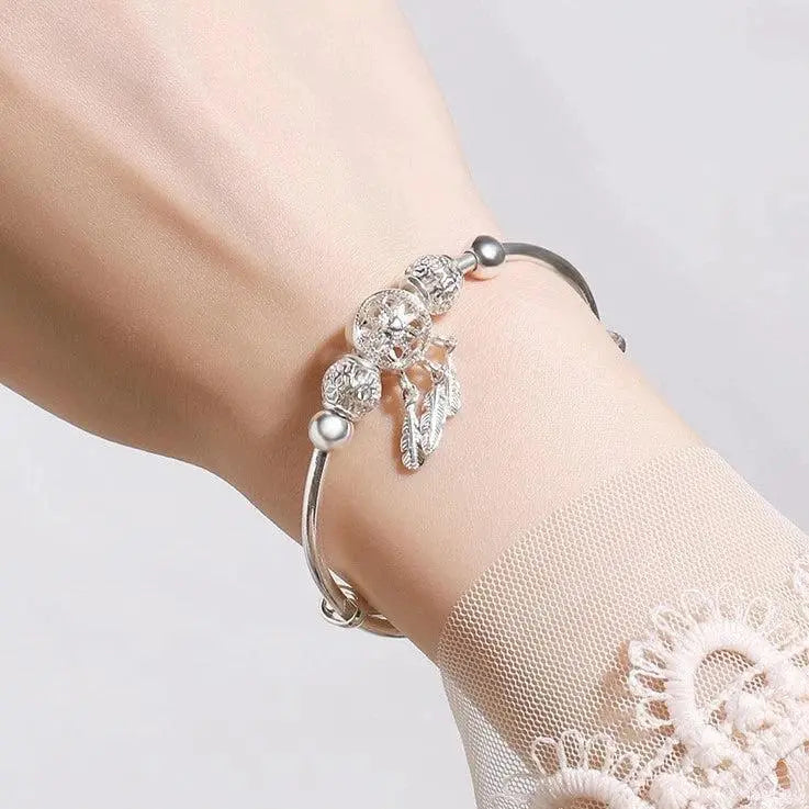 Filigree dreamcatcher bracelet with feather pendants and decorative beads
