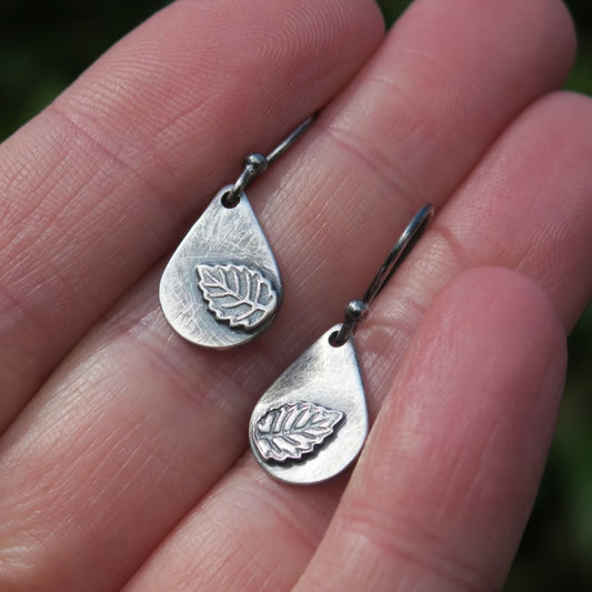 Teardrop-shaped earrings featuring delicate leaves and sky-blue glass beads