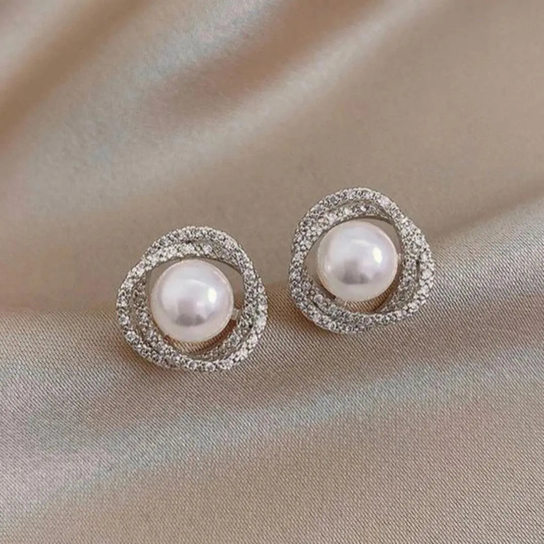 Elegant pearl earrings featuring a spiral design set with sparkling diamonds