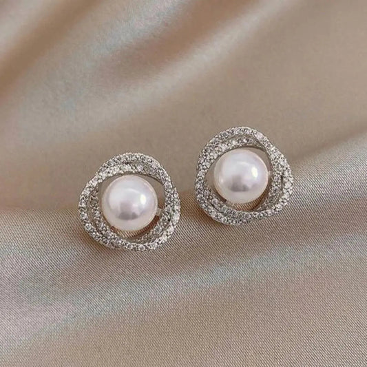 Elegant pearl earrings featuring a spiral design set with sparkling diamonds