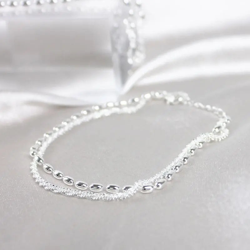 A glamorous cubic zirconia bracelet with an elegant pearl necklace