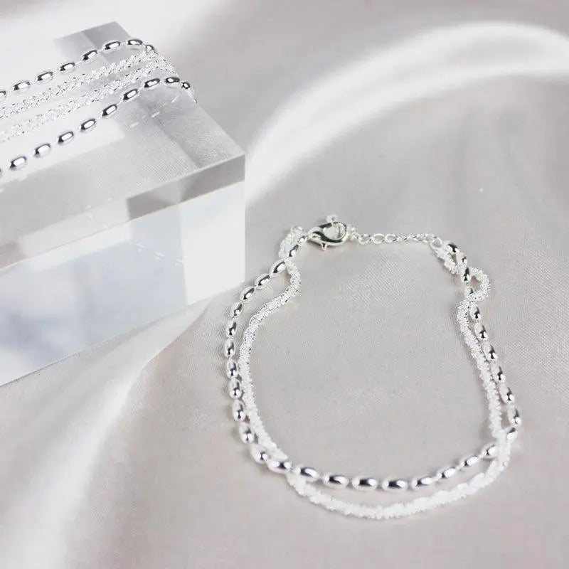 A glamorous cubic zirconia bracelet with an elegant pearl necklace