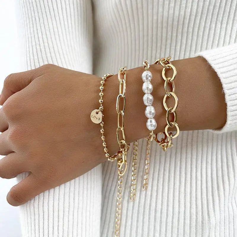 An elegant set of bracelets featuring pearls, chains and a ‘love’ necklace
