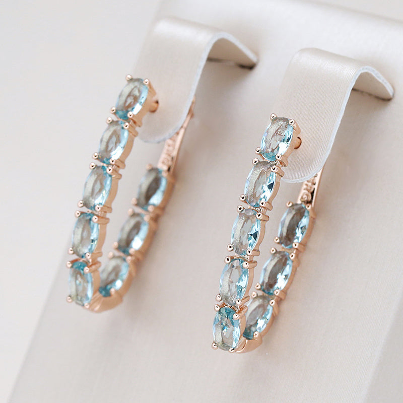 Hoop earrings with light blue oval cubic zirconia stones that look like roses
