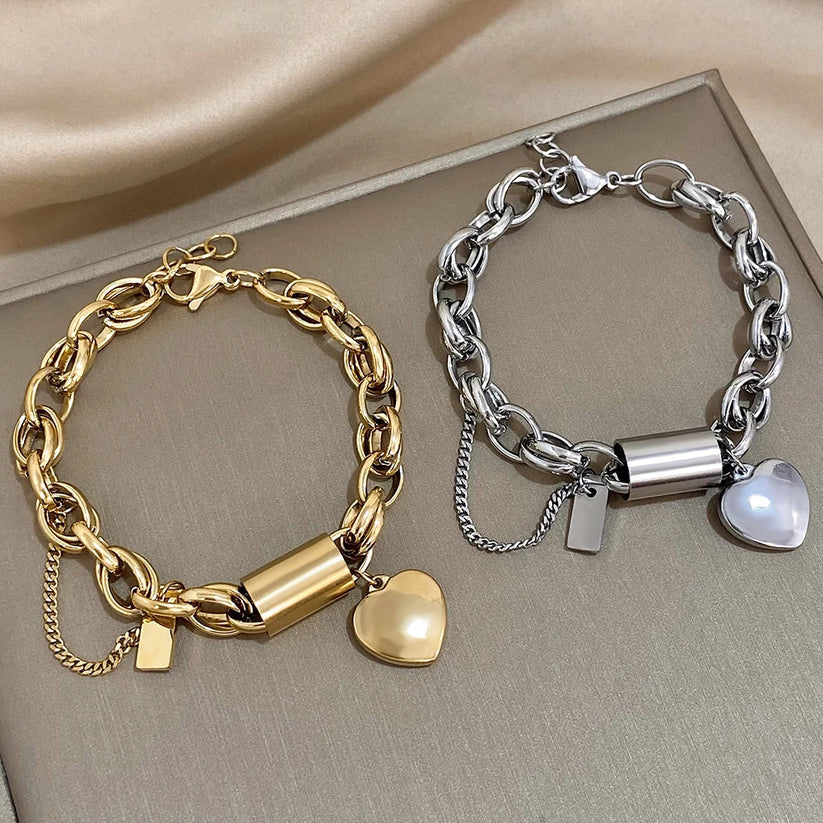 Modern bracelet with a chunky link chain and a heart and cylinder pendant