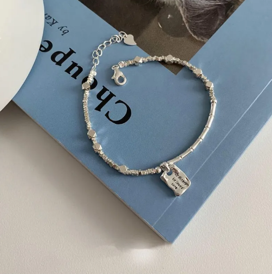 A glamorous bracelet featuring geometric elements, heart-shaped details and pearls