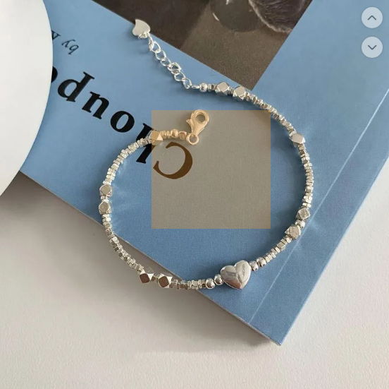 A glamorous bracelet featuring geometric elements, heart-shaped details and pearls