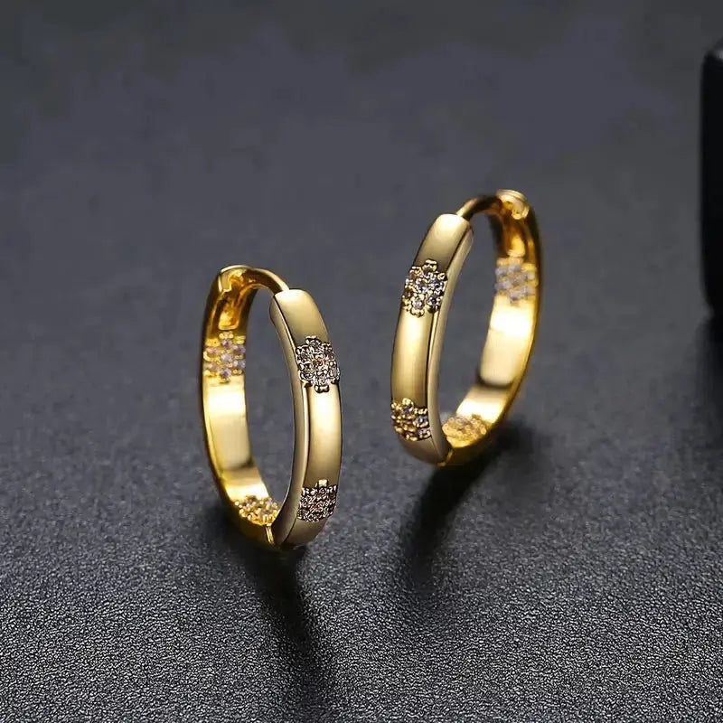 Gold-plated hoop earrings with floral motifs featuring sparkling cubic zirconia stones