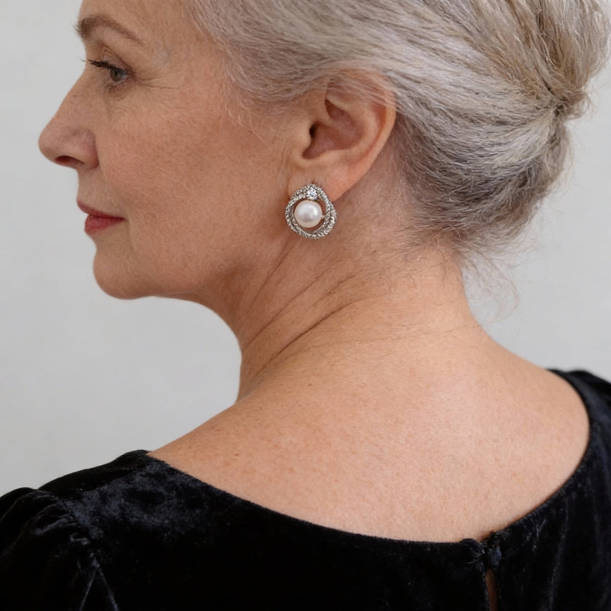 Elegant pearl earrings featuring a spiral design set with sparkling diamonds
