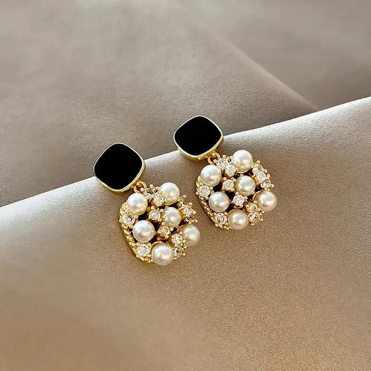 Elegant earrings featuring black squares and sparkling pearls