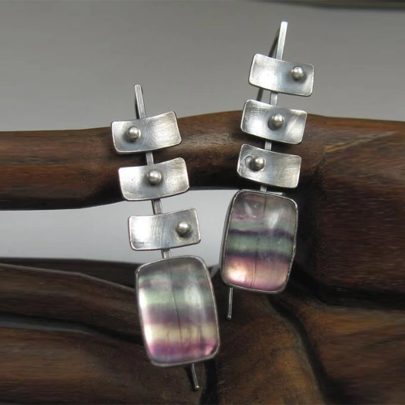 Modern earrings featuring rainbow fluorite stones and geometric elements