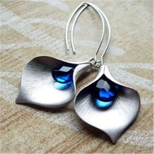 Elegant earrings featuring teardrop-shaped blue crystals in a lotus design