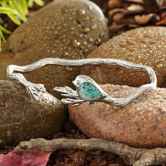 Bracelet featuring a bird-on-a-branch design in turquoise with an antique finish