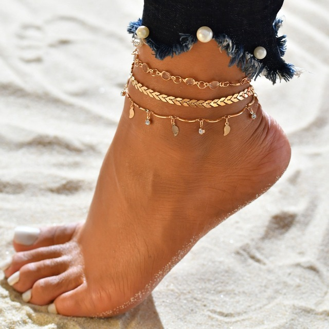 A glamorous set of layered anklets featuring leaf charms and crystals
