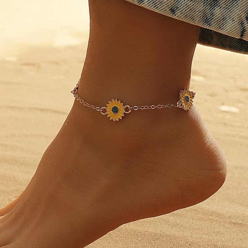 A dainty ankle bracelet with playful yellow sunflower charms