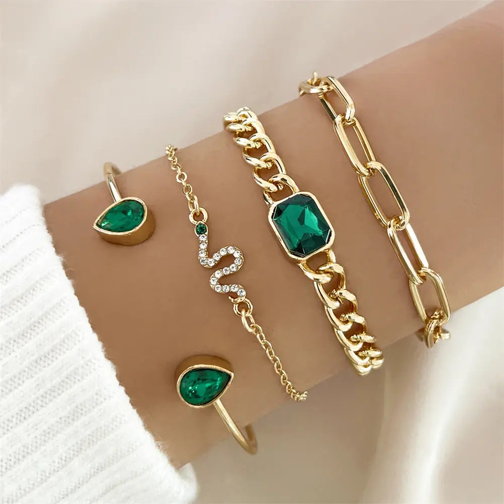 An elegant set bracelet featuring a design of green crystal stones and a snake motif