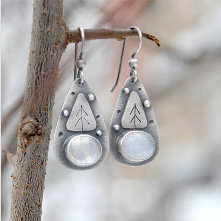 Handmade earrings featuring moonstone and tree motifs