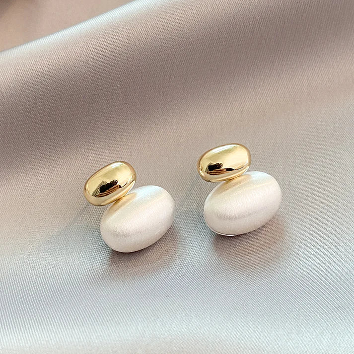 Elegant earrings with teardrop-shaped elements and a pearly finish