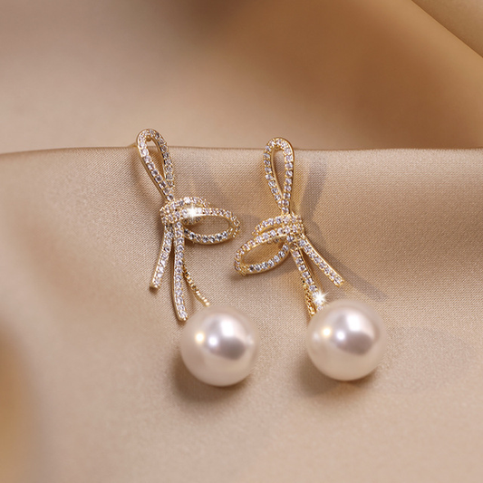 Elegant bow-shaped earrings with sparkling cubic zirconia and pearls