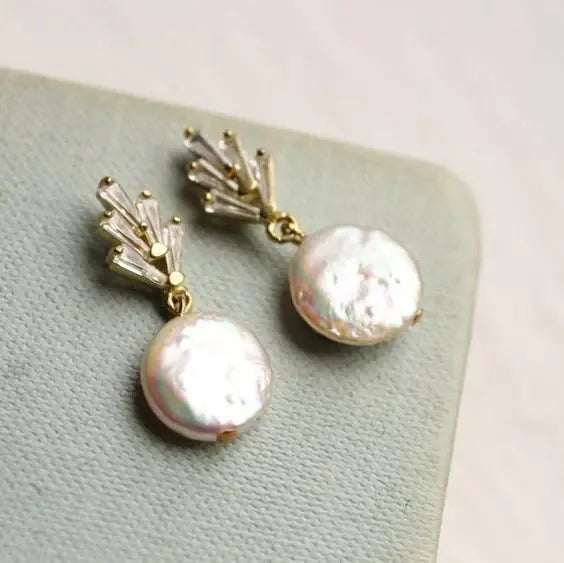 Elegant earrings featuring baroque pearls and dangling cubic zirconia stones