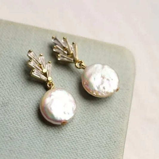 Elegant earrings featuring baroque pearls and dangling cubic zirconia stones