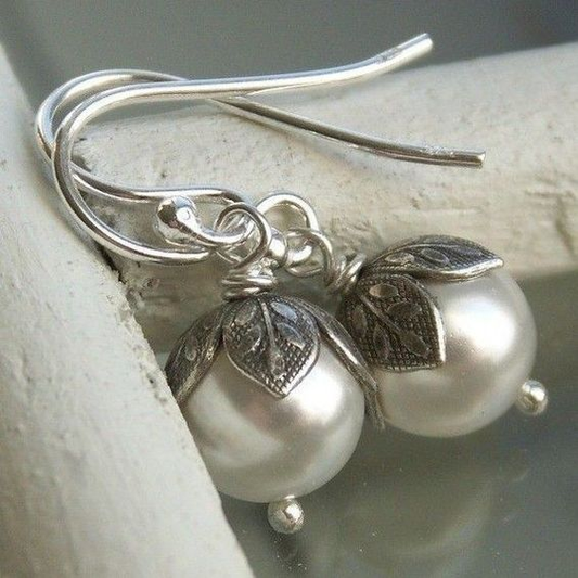 Elegant vintage pearl earrings with artistic leaf-shaped clasps