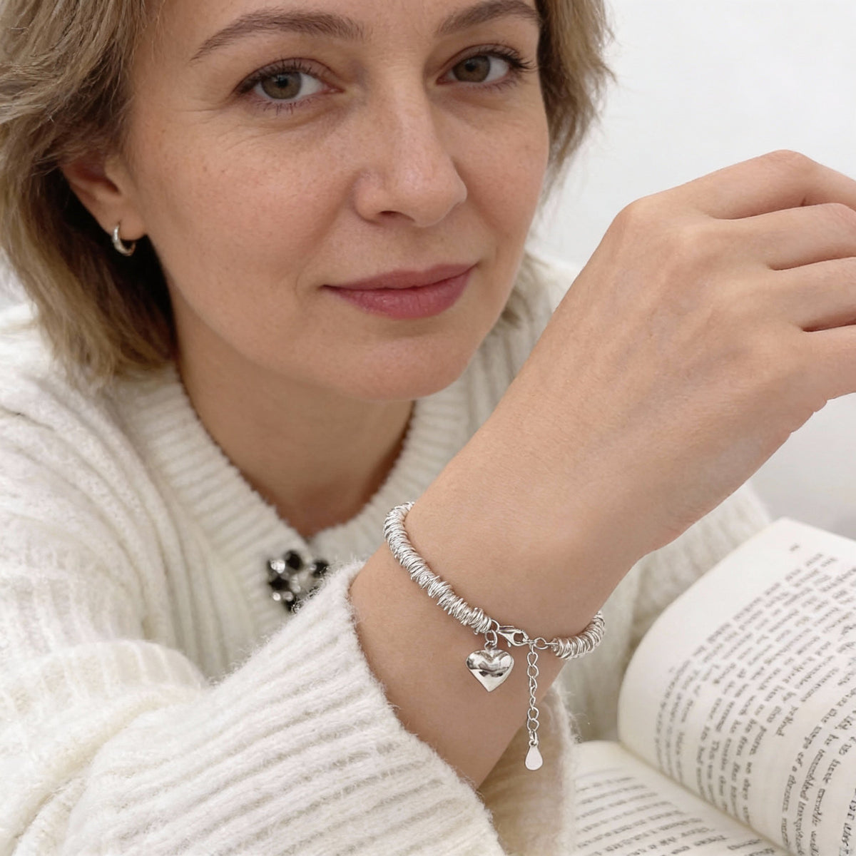 An elegant bracelet featuring a heart-shaped pendant and a spiral ‘resort’ design