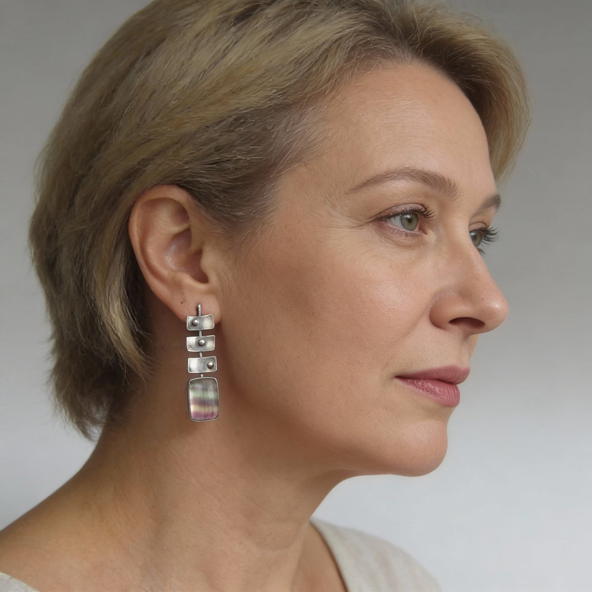Modern earrings featuring rainbow fluorite stones and geometric elements
